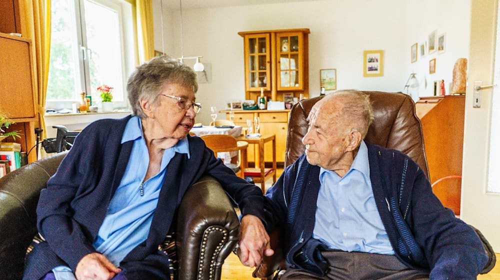 Ursula (l) und Gottfried Schmelzer sitzen in ihrem Wohnzimmer zusammen. / Foto: Andreas Arnold/dpa