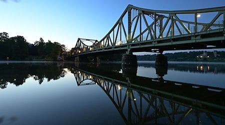 Die Glienicker Brücke spiegelt sich am Morgen im Wasser der Havel. / Foto: Soeren Stache/dpa