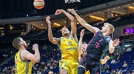 Alba Berlins Louis Olinde (M) springt zum Korb gegen Sam Griesel (r) von den Telekom Baskets Bonn. / Foto: Andreas Gora/dpa