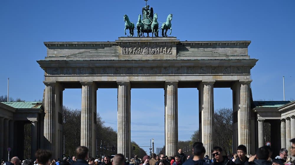 Viele Touristen kommen bei Sonnenschein und blauem Himmel zum Brandenburger Tor, um Erinnerungsfotos zu machen. / Foto: Jonathan Penschek/dpa