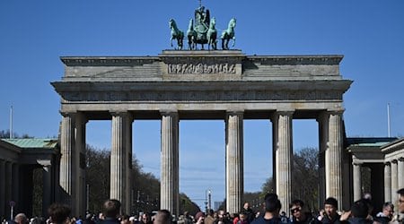 Viele Touristen kommen bei Sonnenschein und blauem Himmel zum Brandenburger Tor, um Erinnerungsfotos zu machen. / Foto: Jonathan Penschek/dpa