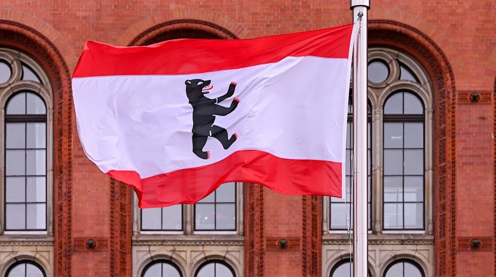 Die rot-weisse Fahne des Landes Berlin mit dem Berliner Bär weht vor dem Roten Rathaus. / Foto: Soeren Stache/dpa