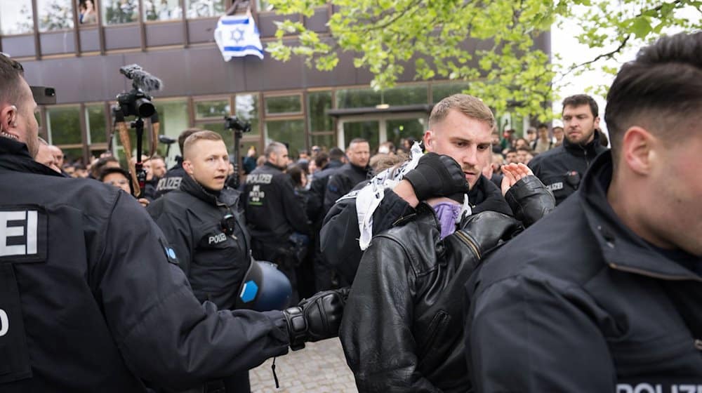 Polizeibeamte bringen während einer propalästinensischen Demonstration der Gruppe «Student Coalition Berlin» auf dem Theaterhof der Freien Universität Berlin außerhalb des Camps Demonstranten weg. Die Teilnehmer haben am Dienstagvormittag den Platz mit Zelten besetzt. / Foto: Sebastian Christoph Gollnow/dpa