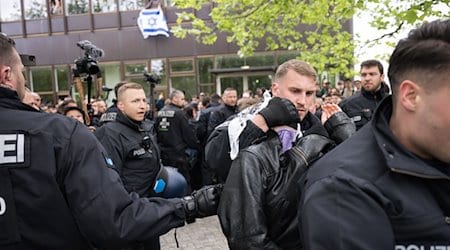 Polizeibeamte bringen während einer propalästinensischen Demonstration der Gruppe «Student Coalition Berlin» auf dem Theaterhof der Freien Universität Berlin außerhalb des Camps Demonstranten weg. Die Teilnehmer haben am Dienstagvormittag den Platz mit Zelten besetzt. / Foto: Sebastian Christoph Gollnow/dpa