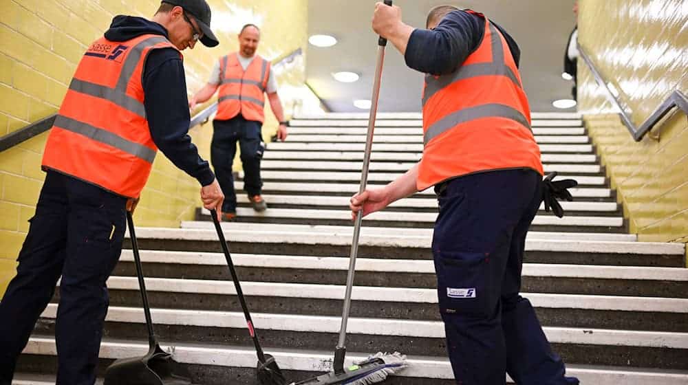 Reinigungskräfte arbeiten auf einer Treppe in der U-Bahnline U8. / Foto: Jens Kalaene/dpa