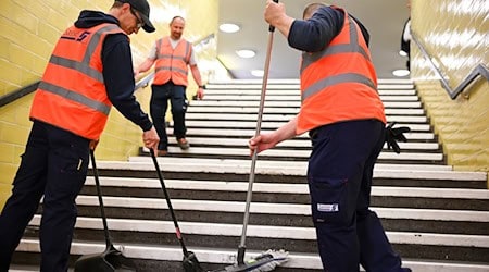 Reinigungskräfte arbeiten auf einer Treppe in der U-Bahnline U8. / Foto: Jens Kalaene/dpa