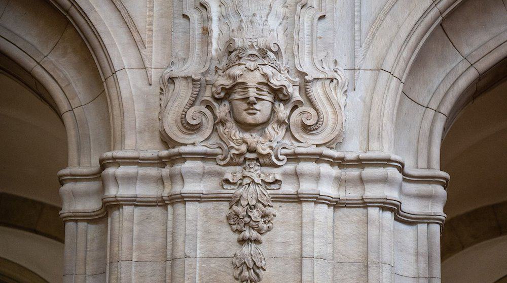 Ein Relief mit einer Abbildung der Gerechtigkeitsgöttin Justitia an einer Säule in einem Gerichtsgebäude. / Foto: Monika Skolimowska/dpa/Symbolbild