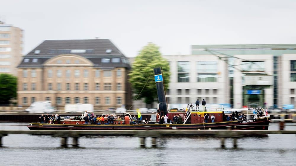 Dampfschlepper Andreas fährt beim Andampfen zwischen Oberbaumbrücke und Molecule Man auf der Spree. / Foto: Christoph Soeder/dpa