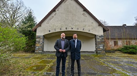 Daniel Kurth (l), Landrat vom Landkreis Barnim, und Oliver Borchert, Bürgermeister von Wandlitz, stehen vor der Villa von Nazi-Minister Goebbels auf dem Areal am Bogensee. / Foto: Patrick Pleul/dpa