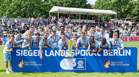 Spieler von Viktoria Berlin feiern mit der Siegertrophäe den Landespokalsieg. / Foto: Matthias Koch/dpa