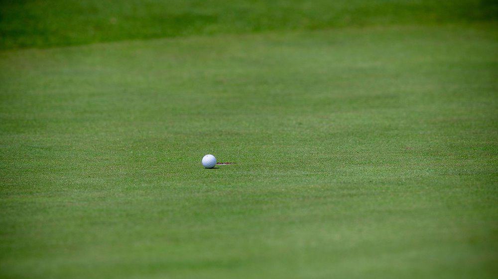 Ein Golfball liegt wenige Zentimeter vor dem Loch. / Foto: Jens Büttner/dpa-Zentralbild/dpa/Symbolbild