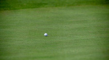 Ein Golfball liegt wenige Zentimeter vor dem Loch. / Foto: Jens Büttner/dpa-Zentralbild/dpa/Symbolbild