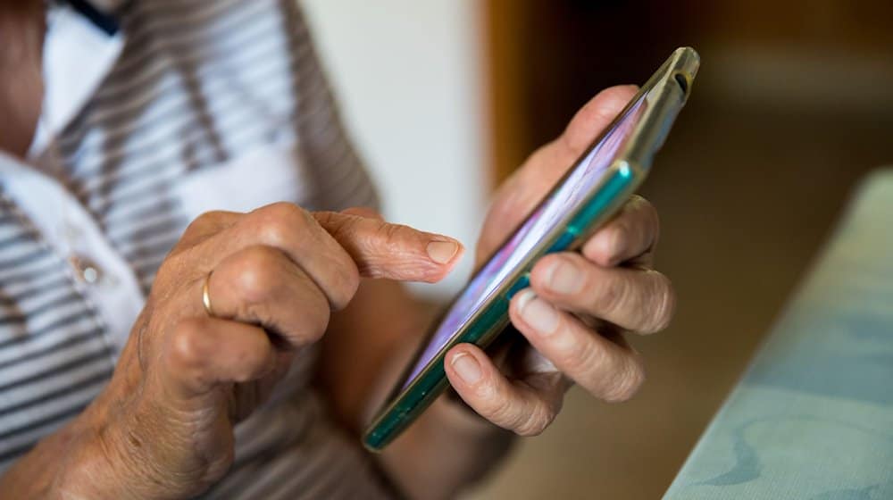 Eine Seniorin bedient ein Mobiltelefon (Smartphone). / Foto: Daniel Karmann/Deutsche Presse-Agentur GmbH/dpa