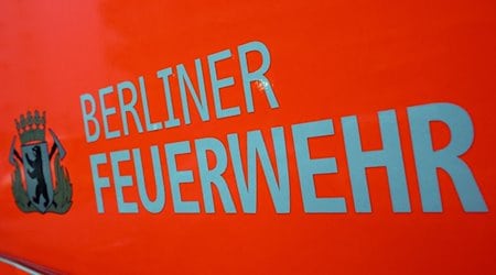 Der Schriftzug „Berliner Feuerwehr“ und das Wappen Berliner Feuerwehr mit dem Berliner Bären stehen auf der Tür eines Feuerwehrfahrzeuges. / Foto: Soeren Stache/dpa