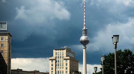 Dunkle Regenwolken sind über dem Fernsehturm zu sehen. Mit Gewittern und heftigen Regenfällen beginnt die Woche in Berlin und Brandenburg. / Foto: Christophe Gateau/dpa