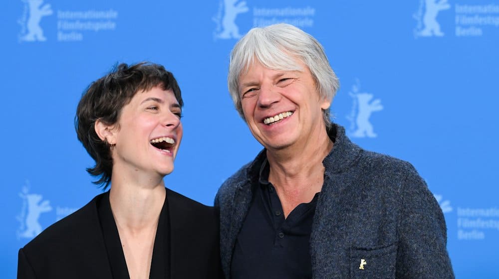 Andreas Dresen (r) und Liv Lisa Fries (l) lachen beim Photocall ihres Films «In Liebe, Eure Hilde» in Berlin. / Foto: Soeren Stache/dpa