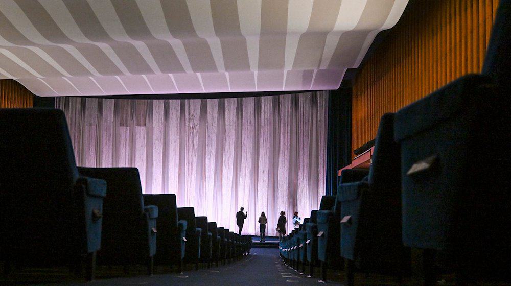 Bei einer Presseführung wird im Kino International der Zuschauerraum mit dem Vorhang vor der Kinoleinwand gezeigt. / Foto: Jens Kalaene/dpa
