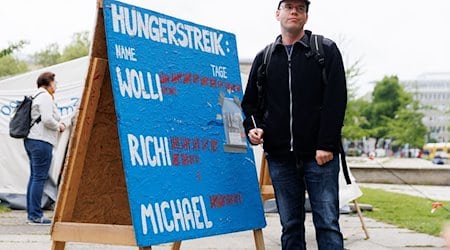 Der Klimaaktivist Adrian Lack vom Bündnis «Hungern bis ihr ehrlich seid» steht neben einer Tafel mit der Liste der Anzahl von Hungerstreik-Tagen. / Foto: Carsten Koall/dpa