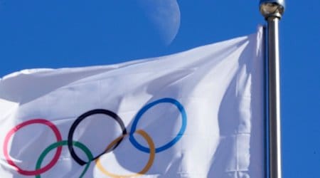 Eine olympischen Flagge weht vor blauem Himmel im Wind. / Foto: Dmitri Lovetsky/AP/dpa/Symbolbild