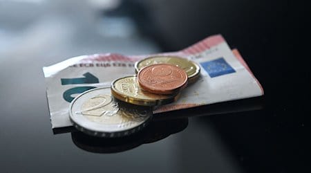 Münzen und ein Geldschein im Wert von 12,41 Euro liegen auf einer schwarzen Fläche (gestellte Szene). / Foto: Marijan Murat/dpa
