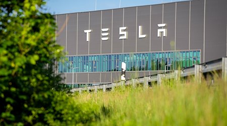 Der Schriftzug „Tesla“ steht an der Fassade eines Gebäudes der Tesla Gigafactory. / Foto: Soeren Stache/dpa