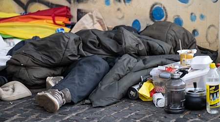 Eine Person liegt in der Innenstadt unter einem Schlafsack. / Foto: Marijan Murat/dpa/Archivbild