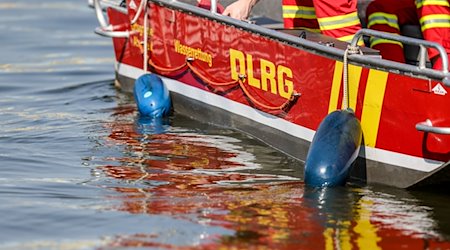 Ein Motorboot der DLRG fährt über einen Fluss. / Foto: Christoph Reichwein/dpa