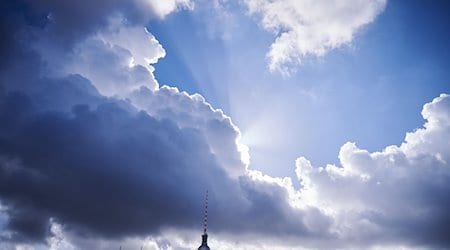 Die Sonnenstrahlen kommen hinter einer dunklen Wolke über dem Fernsehturm hervor. / Foto: Annette Riedl/dpa/Archivbild