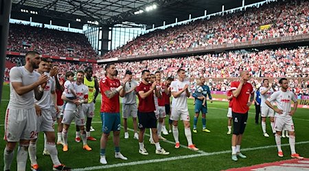 Kölns Spieler stehen nach dem Spiel vor den Fans. / Foto: Federico Gambarini/dpa