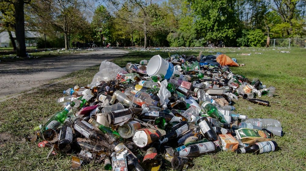 Unzählige Flaschen und Müll liegen in einem Park in Treptow. / Foto: Paul Zinken/dpa