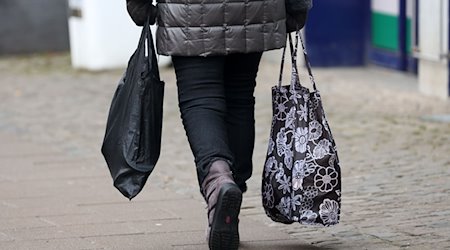 Eine Frau geht mit Einkaufstaschen durch die Stadt. / Foto: Bernd Wüstneck/dpa/Symbolbild