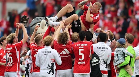 Berlins Torwart Jakob Busk wird nach dem Sieg zum Klassenerhalt vom Team verabschiedet. / Foto: Andreas Gora/dpa