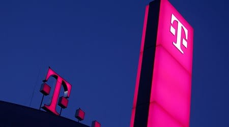 Das Logo der Deutschen Telekom leuchtet auf dem Dach der Unternehmenszentrale. / Foto: Oliver Berg/dpa