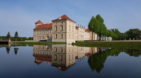 Die Parkseite von Schloss Rheinsberg mit dem Kurt Tucholsky Literaturmuseum spiegelt sich in dem vom Grienericksee gespeisten Wasser des Schlossgrabens. / Foto: Soeren Stache/dpa