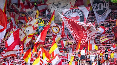 Fußball: Bundesliga, 1. FC Union Berlin - VfL Bochum, 32. Spieltag, An der Alten Försterei. Fans von Union Berlin feuern ihr Team mit Fahnen und Schals an. / Foto: Andreas Gora/dpa