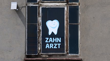 «Zahnarzt» steht an einem Fenster eines Hauses, in dem sich eine Zahnarztpraxis befindet, geschrieben. / Foto: Robert Michael/dpa-Zentralbild/dpa/Symbolbild