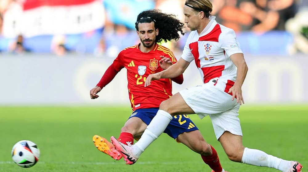 Spaniens Marc Cucurella (l) und Kroatiens Lovro Majer kämpfen um den Ball. / Foto: Andreas Gora/dpa