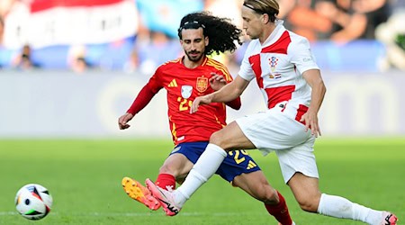 Spaniens Marc Cucurella (l) und Kroatiens Lovro Majer kämpfen um den Ball. / Foto: Andreas Gora/dpa