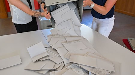 Kurz nach 18 Uhr werden die Stimmzettel aus der Wahlurne zur Europawahl ausgeschüttet. / Foto: Patrick Pleul/dpa