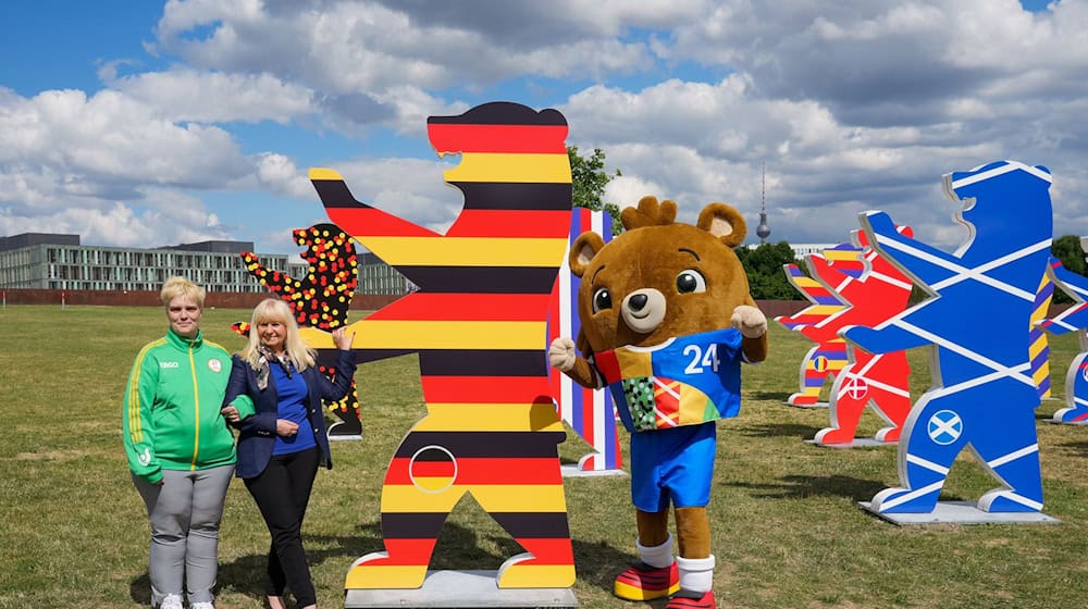 Iris Spranger (SPD, 2.v.l), Senatorin für Inneres und Sport, steht zur Eröffnung des Kunstprojektes «Nationenbären» im Spreebogenpark neben Maskottchen Albärt (r) und der freiwilligen Helferin Viola (l). / Foto: Soeren Stache/dpa