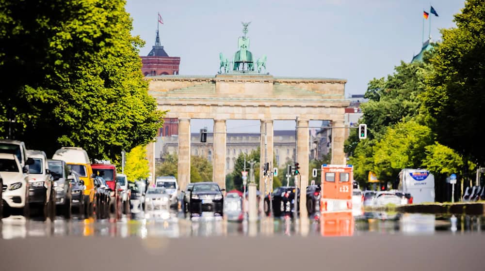 Die Straße des 17. Juni spiegelt von der Hitze vor dem Brandenburger Tor. / Foto: Christoph Soeder/dpa