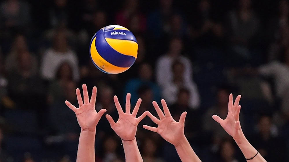 SYMBOLBILD - Hände an einem Volleyball. / Foto: Silas Stein/dpa