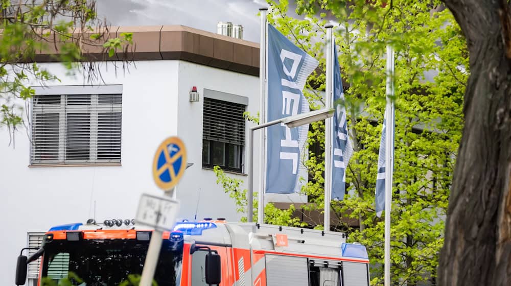 Flaggen der Firma Diehl sind in Berlin-Lichterfelde bei einem Brand zu sehen. / Foto: Christoph Soeder/dpa/Archivbild