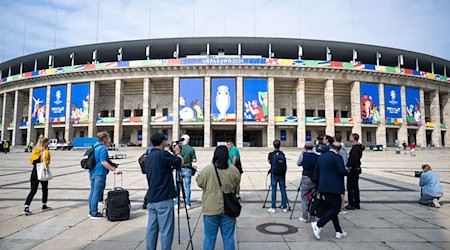 Pressevertreter filmen und fotografieren das Olympiastadion, das für die UEFA EURO 2024 geschmückt ist. / Foto: Christophe Gateau/dpa