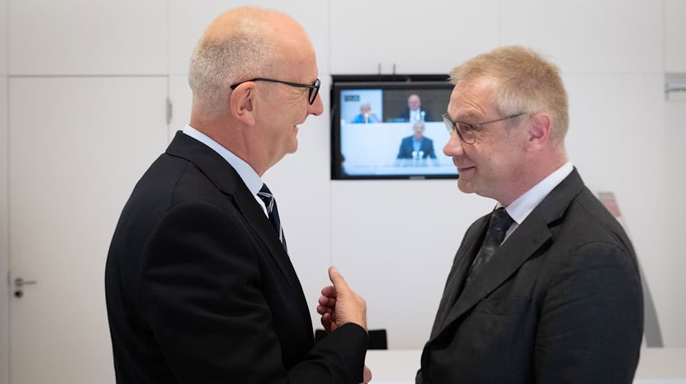 Dietmar Woidke (l, SPD), Ministerpräsident von Brandenburg, gratuliert Andreas Büttner (r, Die Linke). / Foto: Soeren Stache/dpa