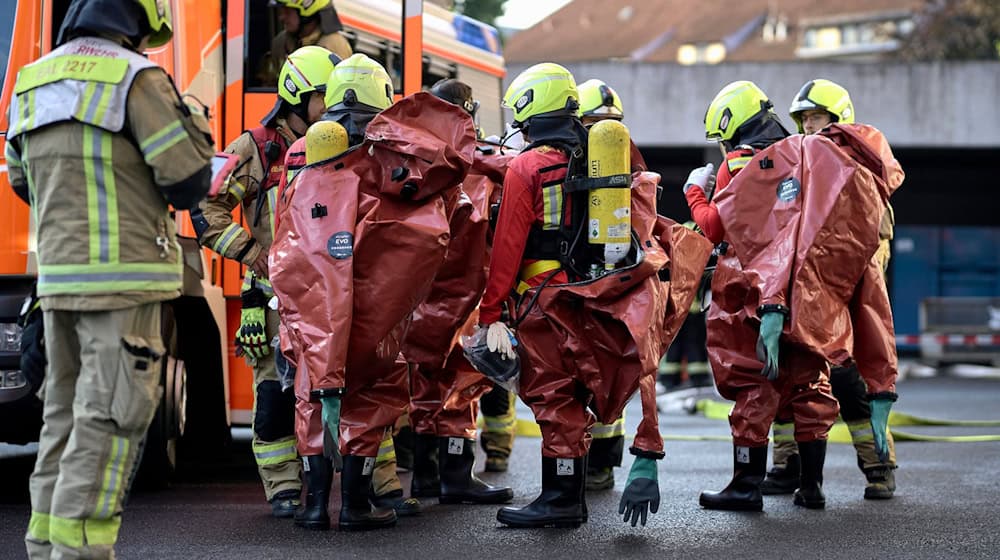 Feuerwehrleute stehen in Schutzausrüstung nach einem Alarm in einem Hochsicherheitslabor am Robert Koch-Institut. / Foto: Michael Ukas/dpa