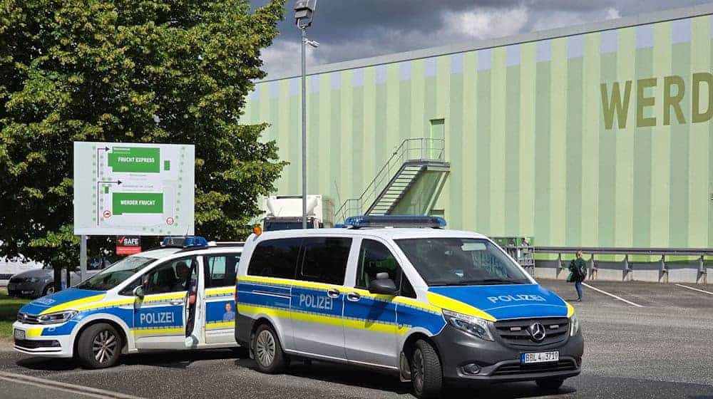 Polizisten sperren die Zufahrt zu einem  Großhandel für Obst und Gemüse ab. In dem Obst-Großhandel im Landkreis Potsdam-Mittelmark hat es zum wiederholten Mal einen Polizeieinsatz gegeben, sagte eine Sprecherin der Polizei. / Foto: Cevin Dettlaff/dpa