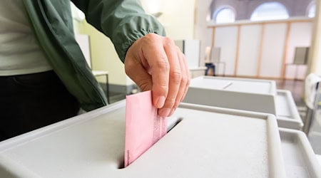 Ein Mann wirft seinen Stimmzettel in eine Urne. / Foto: Julian Stratenschulte/dpa/Symbolbild