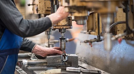 Ein Mitarbeiter bedient in der Produktionshalle eine Maschine zur Verarbeitung von Metall. / Foto: Monika Skolimowska/dpa-Zentralbild/dpa/Symbolbild