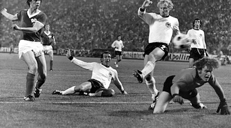 Der Höhepunkt des «Dramas» vom 22.06.1974 im Hamburger Volksparkstadion ist erreicht - auf den Knien blickt Sepp Maier fassungslos dem Ball hinterher, der zum 1:0-Sieg für die DDR ins bundesdeutsche Netz fliegt - getreten von Jürgen Sparwasser (l.). / Foto: Roland Witschel/dpa